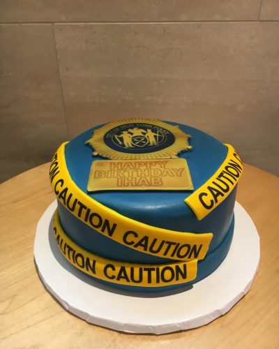 Custom police badge birthday cake with caution tape fondant decoration, Mia's Brooklyn Bakery NYC