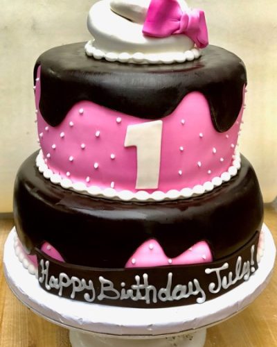 Custom three-tier pink and chocolate first birthday cake with fondant decorations, Mia's Brooklyn Bakery NYC