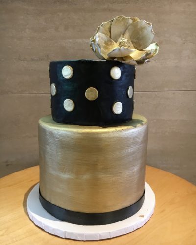 Custom two-tier black and gold fondant cake with gold flower topper, Mia's Brooklyn Bakery NYC
