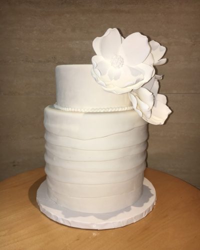 Two-tier white fondant wedding cake with ruffle texture and sugar flower decoration, Mia's Brooklyn Bakery NYC