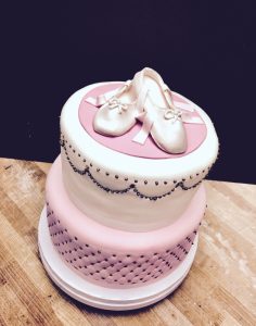 Custom two-tier pink fondant birthday cake with ballet shoe topper and pearl decorations, Mia's Brooklyn Bakery NYC