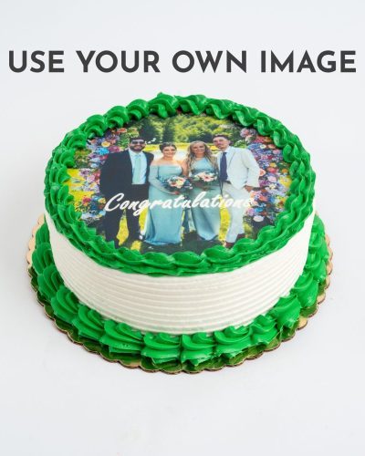 A round custom edible image cake with white textured frosting and bright green buttercream piping, featuring a personalized photo and 'Congratulations' text.